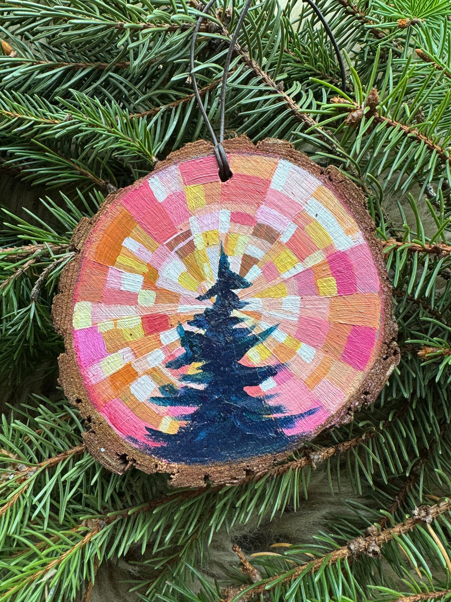 Decorative ornament with a colorful spiral design on a tree branch